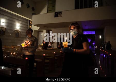 Beirut, Libano, 17 aprile 2020. La gente tiene le candele durante un servizio della chiesa del Venerdì Santo. Alcuni membri della congregazione della chiesa di Sant'Efrem hanno rotto il coprifuoco per osservare il tradizionale servizio del Venerdì Santo durante la chiusura del coronavirus in Libano. Negli anni precedenti, parteciperanno fino a 1500 partecipanti, quest'anno più guardati tramite live streaming su facebook. Elizabeth Fitt Foto Stock