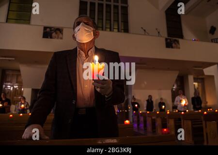 Beirut, Libano, 17 aprile 2020. La gente tiene le candele durante un servizio della chiesa del Venerdì Santo. Alcuni membri della congregazione della chiesa di Sant'Efrem hanno rotto il coprifuoco per osservare il tradizionale servizio del Venerdì Santo durante la chiusura del coronavirus in Libano. Negli anni precedenti, parteciperanno fino a 1500 partecipanti, quest'anno più guardati tramite live streaming su facebook. Elizabeth Fitt Foto Stock