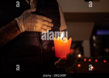 Beirut, Libano, 17 aprile 2020. La gente tiene le candele durante un servizio della chiesa del Venerdì Santo. Alcuni membri della congregazione della chiesa di Sant'Efrem hanno rotto il coprifuoco per osservare il tradizionale servizio del Venerdì Santo durante la chiusura del coronavirus in Libano. Negli anni precedenti, parteciperanno fino a 1500 partecipanti, quest'anno più guardati tramite live streaming su facebook. Elizabeth Fitt Foto Stock
