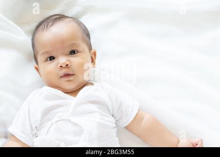 Carino neonato ragazza nella coltre bianca sul letto di vivaio. Adorabili nuovo nato bambino, Little Boy occhi guardano persone famiglia, nuova infanzia, infantili soft skin p Foto Stock