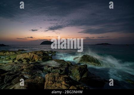 Onde che si schiantano sulle rocce costiere all'alba, Redang Island, Terengganu, Malesia Foto Stock