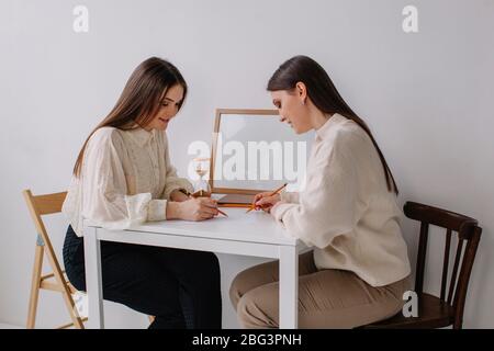 Due donne sedute a un tavolo brainstorming Foto Stock