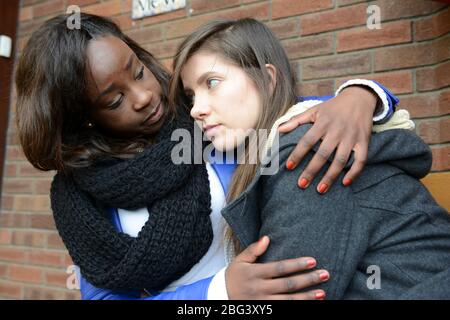 Una giovane donna che soffre di depressione è consolata dal suo amico. Foto Stock