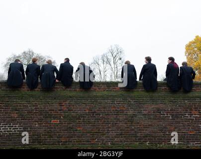 Eton, Windsor, Berkshire, Regno Unito. 20 novembre 2010. I ragazzi dell'Eton College si siedono in cima a un muro alto costruito nel 1717 accanto ai campi da gioco dell'Eton College mentre osservano i loro compagni di scuola competere nel Wall Game. Il primo gioco da parete registrato fu nel 1766. L'Eton College è una scuola pubblica a pagamento, frequentata da molti politici britannici, tra cui Boris Johnson e David Cameron. Anche il Principe William e il Principe Harry frequentarono l'Eton College. Credito: Maureen McLean/Alamy Foto Stock