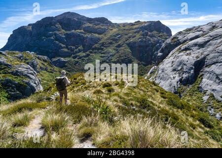 Escursionista che guarda sul Parco Nazionale di Kahurangi da Sentinel Hill vicino al Monte Owen, South Island, Nuova Zelanda Foto Stock