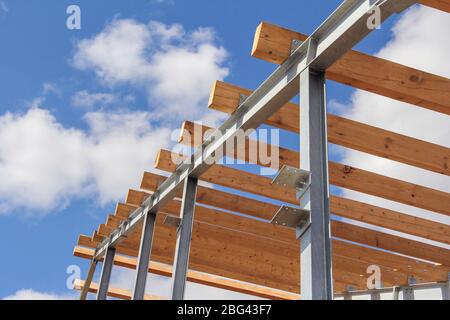 Struttura in acciaio su un nuovo edificio contro il cielo blu con nuvole. Costruzione rapida Foto Stock