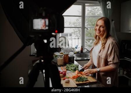 Giovane blogger femminile vlogger e influencer online registrare contenuti video su cibo sano Foto Stock