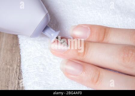 Una donna fa il suo proprio manicure hardware a casa. Primo piano. Set manicure. Pericoloso. Unghie. Cura della casa, salone, Spa, bellezza, salute. Manicure russa Foto Stock