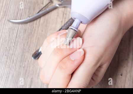 Una donna fa il suo proprio manicure hardware a casa. Primo piano. Set manicure. Pericoloso. Unghie. Cura della casa, salone, Spa, bellezza, salute. Manicure russa Foto Stock