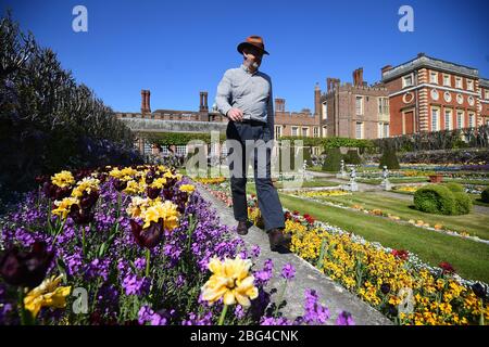 Il responsabile operativo di Gardens and Estates Graham Dillamore cammina nel giardino dello stagno all'Hampton Court Palace, nel sud-ovest di Londra, che è stato temporaneamente chiuso mentre il Regno Unito rimane in blocco durante la pandemia di coronavirus. Foto Stock