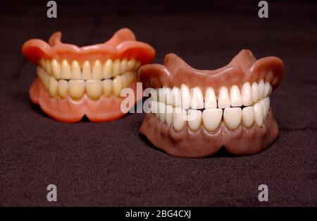 Due serie di protesi complete. Dentature o falsi denti sono realizzati con una base acrilica sulla quale sono montati denti acrilici o ceramici. Le dentiere sono ma personalizzati Foto Stock