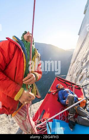 Due uomini che guardano mentre si arrampicano sul naso su El Capitan, Yosemite Foto Stock