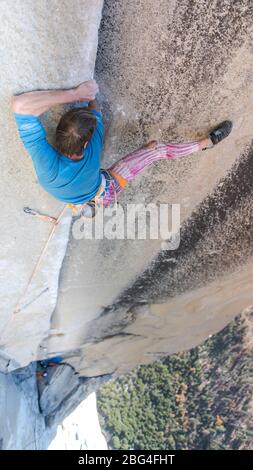 Arrampicata focalizzata e guardando a destra arrampicata duro sul naso Yosemite Foto Stock