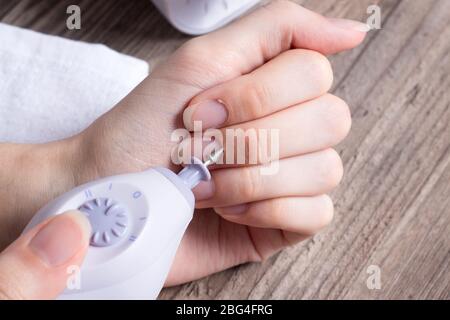 Una donna fa il suo proprio manicure hardware a casa. Primo piano. Set manicure. Pericoloso. Unghie. Cura della casa, salone, Spa, bellezza, salute. Manicure russa Foto Stock