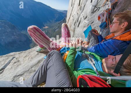 Due scalatori che riposano su una sporgenza all'ombra su El Capitan, Yosemite Foto Stock