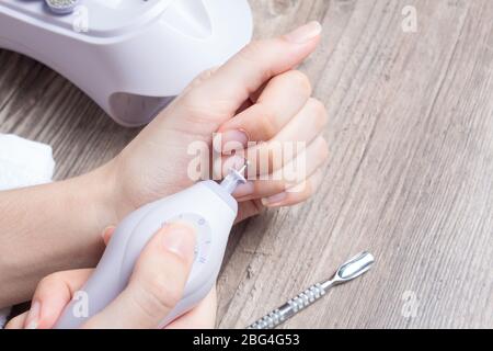 Una donna fa il suo proprio manicure hardware a casa. Primo piano. Set manicure. Pericoloso. Unghie. Cura della casa, salone, Spa, bellezza, salute. Manicure russa Foto Stock