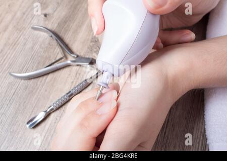 Una donna fa il suo proprio manicure hardware a casa. Set manicure. Pericoloso. Unghie. Cura della casa, salone, Spa, bellezza, salute. Manicure russa Foto Stock