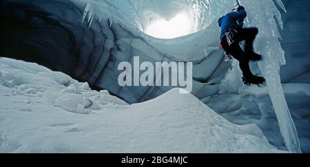 Ghiacciaio scalatore ciclicolo in grotta sotto il ghiacciaio Langjokull Foto Stock