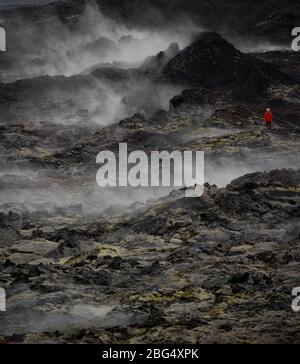 Donna escursioni attraverso il campo di lava al vulcano Krafla Foto Stock