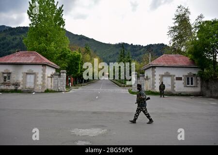 Un trooper paramilitare pattuglia la strada durante un blocco nazionale.il blocco imposto per aiutare a combattere la diffusione di pandemia di coronavirus nella valle del Kashmir è stato esteso fino al 03 maggio 2020. Il numero di casi COVID-19 in Jammu e Kashmir è salito a 354, mentre altre quattro persone hanno provato positivo per il virus, ha detto lunedì. Foto Stock