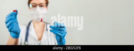 Test per il coronavirus Covid-19. Medico o infermiere che esegue analisi di laboratorio di un tampone nasale in un laboratorio ospedaliero. Tecnico medico che tiene un kit di strisci COVID-19, indossando guanti di protezione da Foto Stock