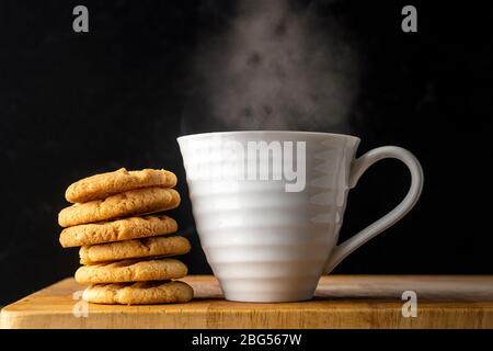 biscotti fatti in casa e una tazza di tè fumante Foto Stock