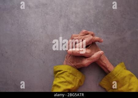 Le mani di una vecchia donna si ripiegano l'una sull'altra. Foto Stock