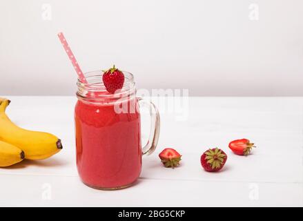 Frullato di fragola e banana o frullato in un vaso di vetro Foto Stock