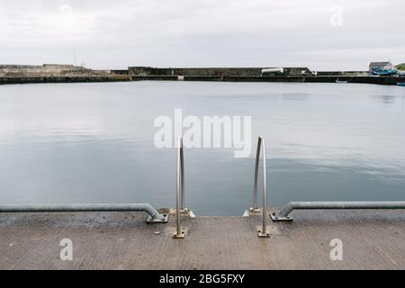 Vista sul porto con scala in primo piano, Wick, Caithness, Scozia, Regno Unito Foto Stock