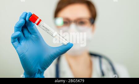 Test per il coronavirus Covid-19. Medico o infermiere che esegue analisi di laboratorio di un tampone nasale in un laboratorio ospedaliero. Tecnico medico che tiene un kit di strisci COVID-19, indossando guanti di protezione da Foto Stock