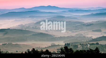 Toscana paesaggio collinare in scena con la mattina presto haze sulla campagna di villaggio Foto Stock