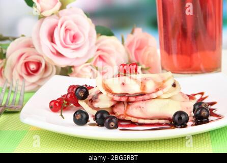 Gustosi gnocchi dolci con frutti di bosco freschi su piatto bianco, su sfondo luminoso Foto Stock