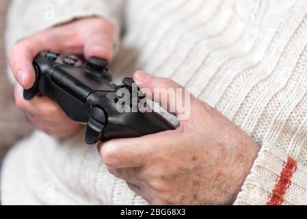 Primo piano del controller di gioco video di tenuta di mano senior . Foto Stock