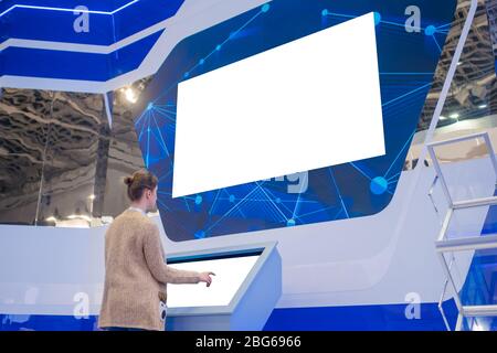 Donna che guarda la grande vuoto interactive Wall display - schermata bianca concept Foto Stock