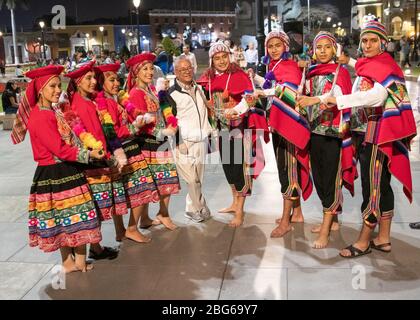 Ballerini maschili e femminili in costumi colorati che eseguono la danza tradizionale peruviana alla folla nella piazza principale di Trujillo nel Perù settentrionale Foto Stock