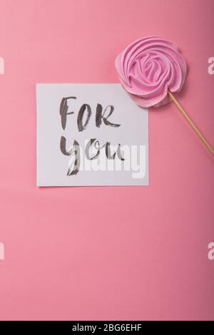 Per voi iscrizione manoscritta. Carta disegnata a mano, calligraphy. Con Rosa Rosa caramella in colori pastello su un bastone di legno su un backgrou grigio Foto Stock