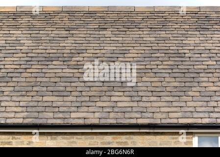 Ricostituito 'finishing' Stonesfield tetto ardesia su una nuova casa, Charlbury, Oxfordshire Foto Stock