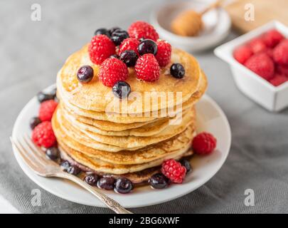 Dolci pancake fatti in casa con frutta su piatto bianco. Foto Stock
