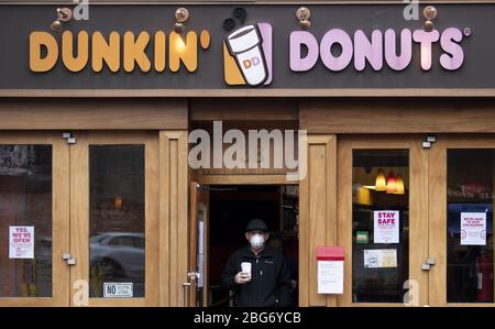 Annapolis, Stati Uniti. 20 aprile 2020. Un uomo indossa una maschera mentre lascia un negozio Dunkin' Donuts nel centro di Annapolis, Maryland, in mezzo alla pandemia Coronavirus COVID-19 Lunedi, 20 aprile 2020. Gov. Larry Hogan, R-MD, ha recentemente superato un ordine che richiede a tutte le persone di indossare una copertura viso prima di entrare in qualsiasi stabilimento di vendita al dettaglio. Foto di Kevin Dietsch/UPI Credit: UPI/Alamy Live News Foto Stock