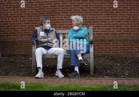 Annapolis, Stati Uniti. 20 aprile 2020. La gente indossa maschere mentre siedono su una panchina nel centro di Annapolis, Maryland, in mezzo alla pandemia Coronavirus COVID-19 il Lunedi, 20 aprile 2020. Gov. Larry Hogan, R-MD, ha recentemente superato un ordine che richiede a tutte le persone di indossare una copertura viso prima di entrare in qualsiasi stabilimento di vendita al dettaglio. Foto di Kevin Dietsch/UPI Foto Stock