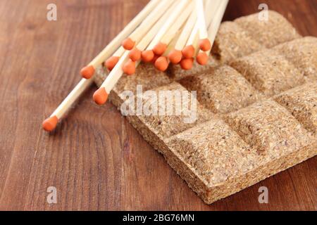 Fiammiferi lunghi e combustibile secco, su sfondo di legno Foto Stock