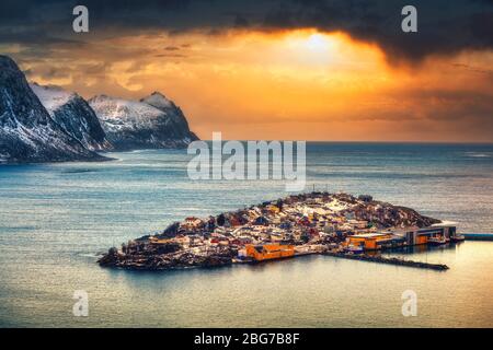 Spettacolare cielo al tramonto sul villaggio di pescatori dell'isola di Husøy nel fiordo. Foto Stock