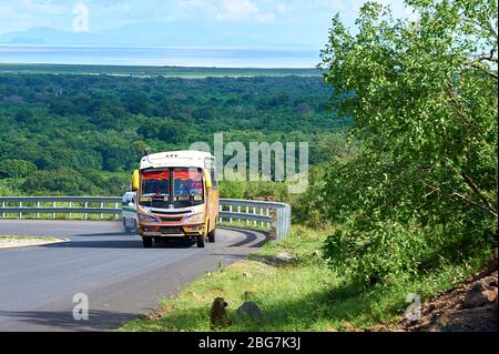 Un autobus pubblico si torce in salita sulla ripida Lake Manyara Escarpment Road, Tanzania settentrionale Foto Stock