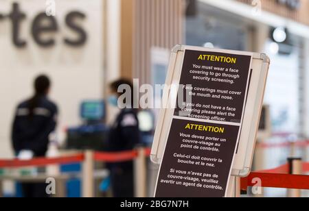 Toronto, Canada. 20 aprile 2020. Un avviso sui nuovi requisiti di copertura facciale è stato osservato durante l'epidemia di COVID-19 all'aeroporto internazionale Pearson di Toronto, Canada, il 20 aprile 2020. Il Ministro dei Trasporti canadese Marc Garneau ha annunciato il 17 aprile una nuova misura che avrà effetto il 20 aprile, richiedendo a tutti i passeggeri delle compagnie aeree di coprire le loro bocche e nasi con una maschera non medica o con altre coperture facciali presso i checkpoint di screening aeroportuali. Credit: Zou Zheng/Xinhua/Alamy Live News Foto Stock