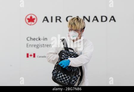 Toronto, Canada. 20 aprile 2020. Un viaggiatore che indossa un equipaggiamento protettivo è visto durante lo scoppio del COVID-19 all'Aeroporto Internazionale Pearson di Toronto, Canada, il 20 aprile 2020. Il Ministro dei Trasporti canadese Marc Garneau ha annunciato il 17 aprile una nuova misura che avrà effetto il 20 aprile, richiedendo a tutti i passeggeri delle compagnie aeree di coprire le loro bocche e nasi con una maschera non medica o con altre coperture facciali presso i checkpoint di screening aeroportuali. Credit: Zou Zheng/Xinhua/Alamy Live News Foto Stock