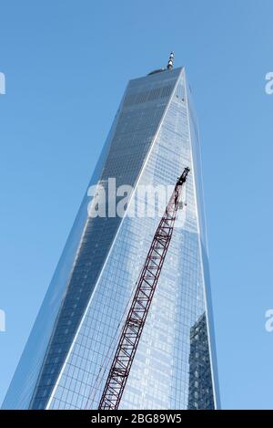 La torre della libertà si trova in primo piano con una grande gru rossa contro un cielo blu. Foto Stock