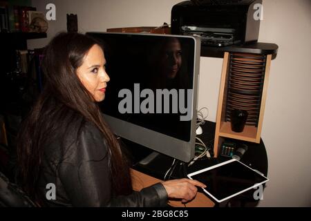 Donna messicana caucasica con occhi color miele lunghi capelli puntando con il dito per accendere Electronic Tablet e iniziare il suo lavoro quotidiano in ufficio a Mex Foto Stock