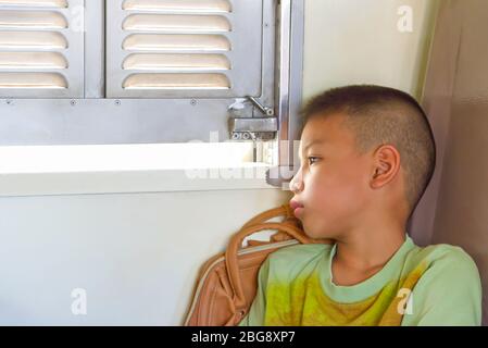 Ritratto di ragazzo asiatico sulla vista della finestra di fondo del treno. Foto Stock