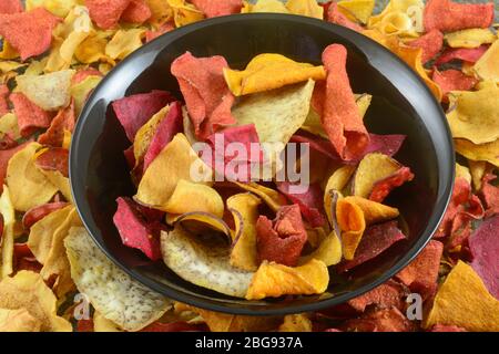 Patatine di taro, patate dolci, batata, pastinache e yucca in ciotola nera Foto Stock