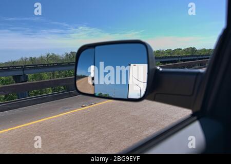 Vista rimorchio rimorchio da specchio laterale. Discesa del veicolo su strada con motore diesel utilizzando gli specchietti di traino per vedere dietro il rimorchio da viaggio. Foto Stock